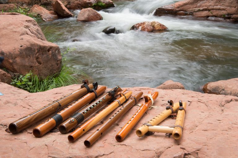 Wooden flutes lying on a rock beside a creek