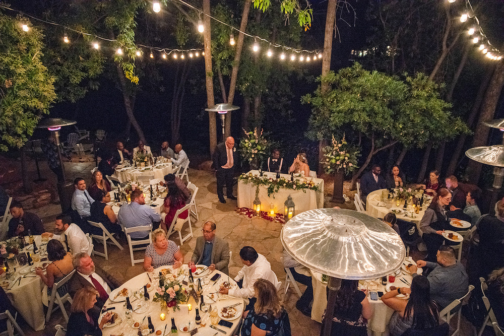 Intimate wedding reception under light surrounded by trees at night in Sedona.