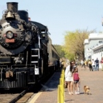 People taking pictures in front of an old locomotive