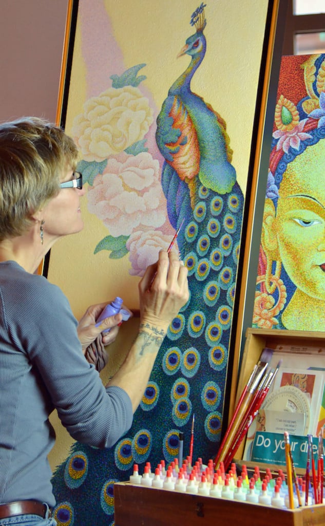 Woman painting picture of peacock