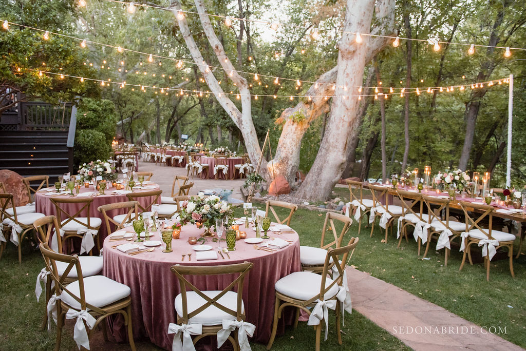 outdoor wedding reception dining area with set tables and string lights