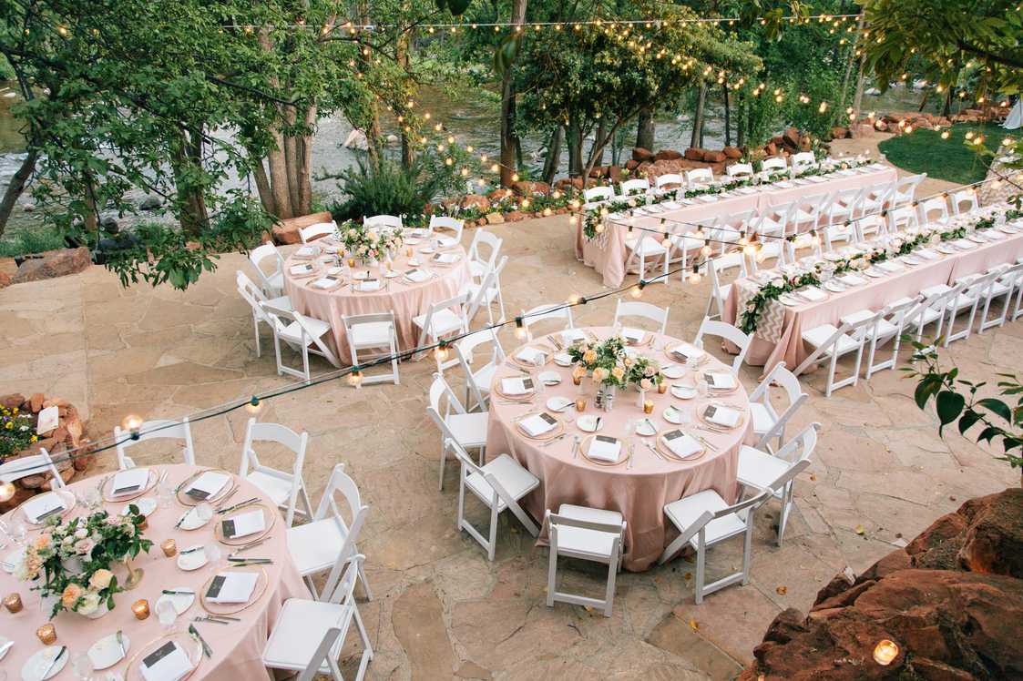 formal wedding dining reception tables outside with trees and creek in the background