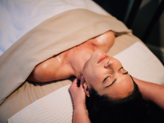 Person on massage bed at L'Apothecary spa