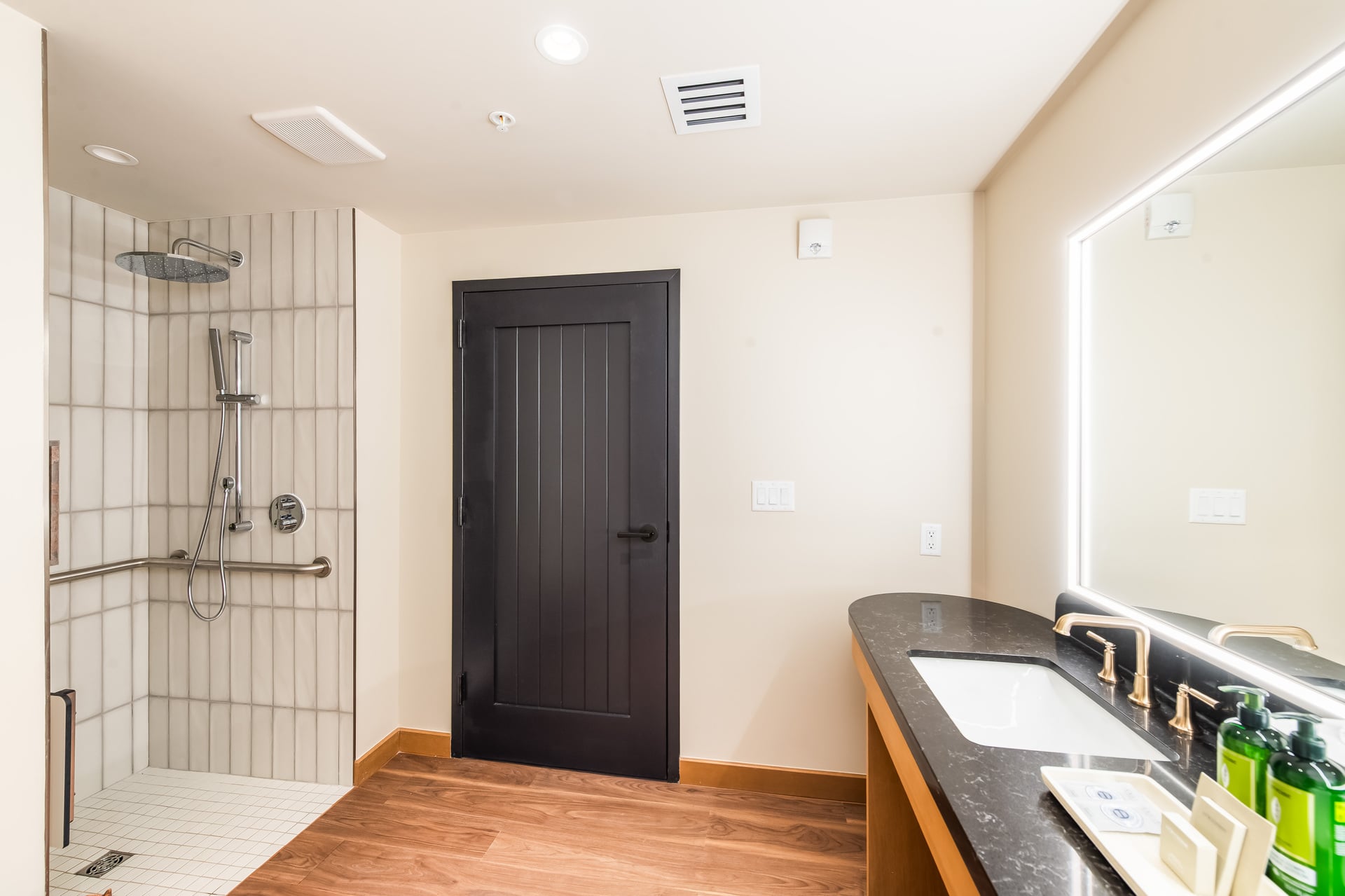 A modern bathroom with a shower, sink, and mirror