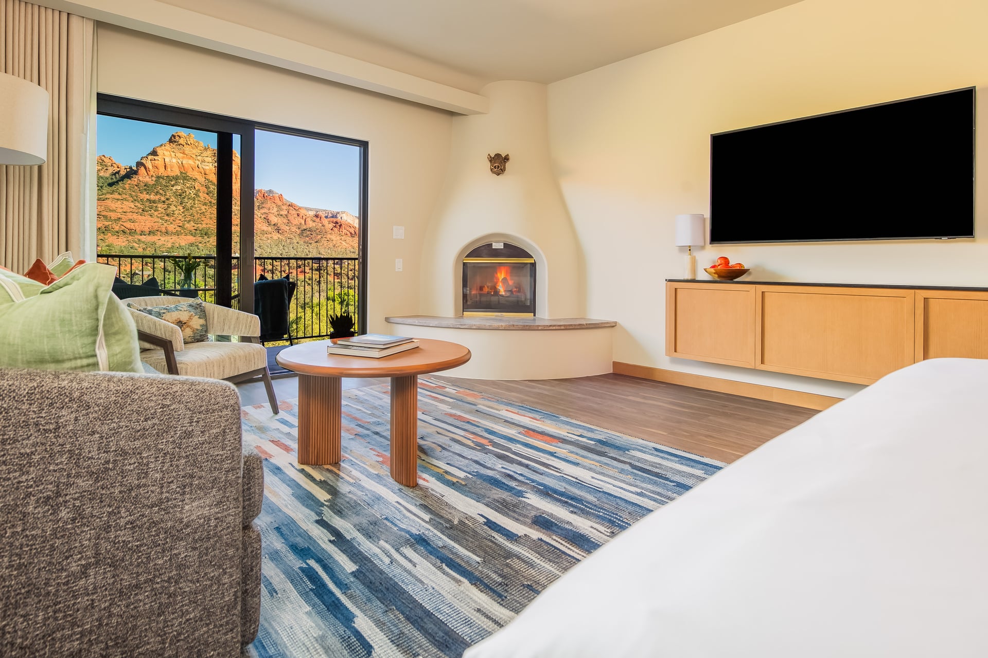 A hotel room with a fireplace, balcony, and mountain view