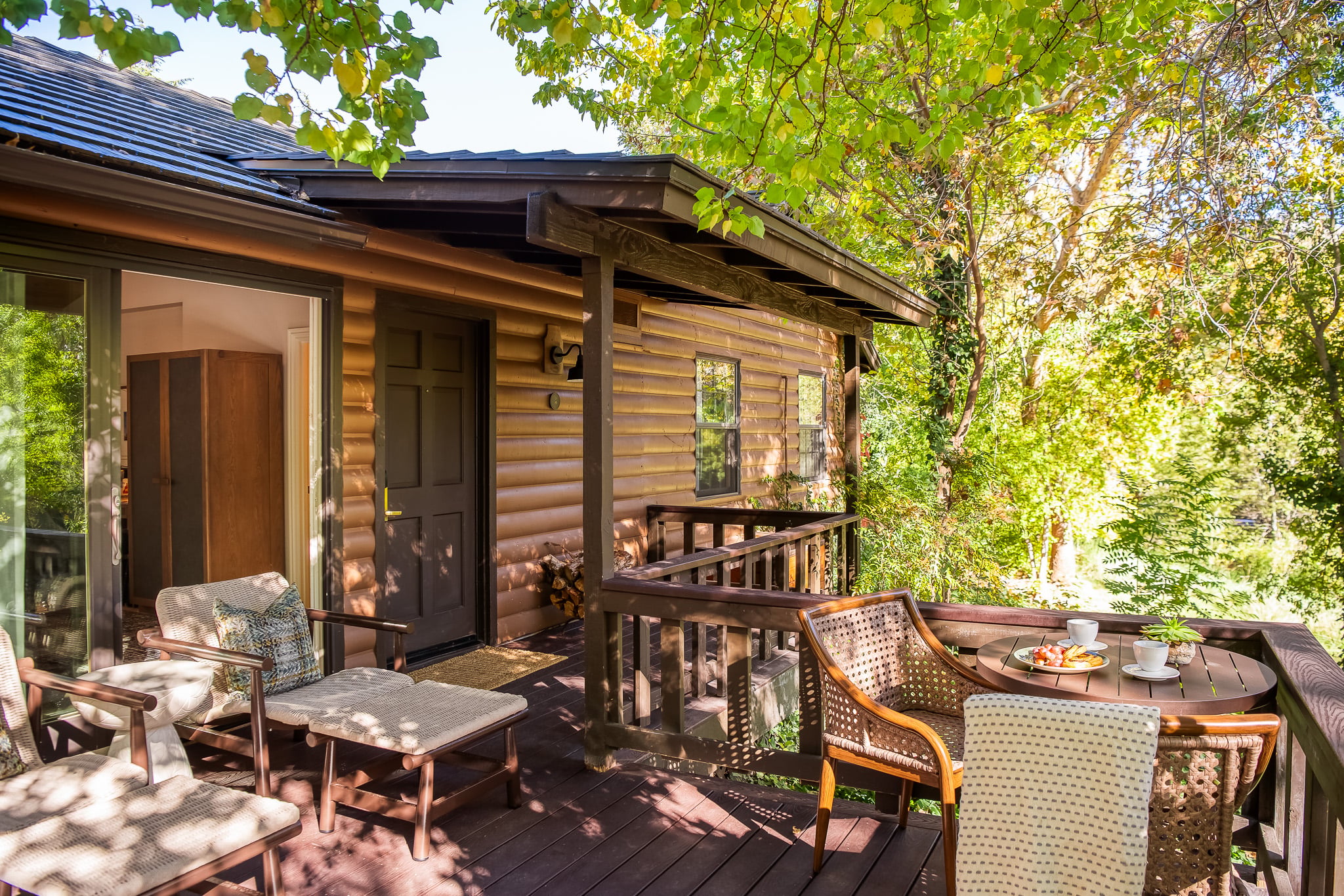 A wooden deck with furniture and a view of trees