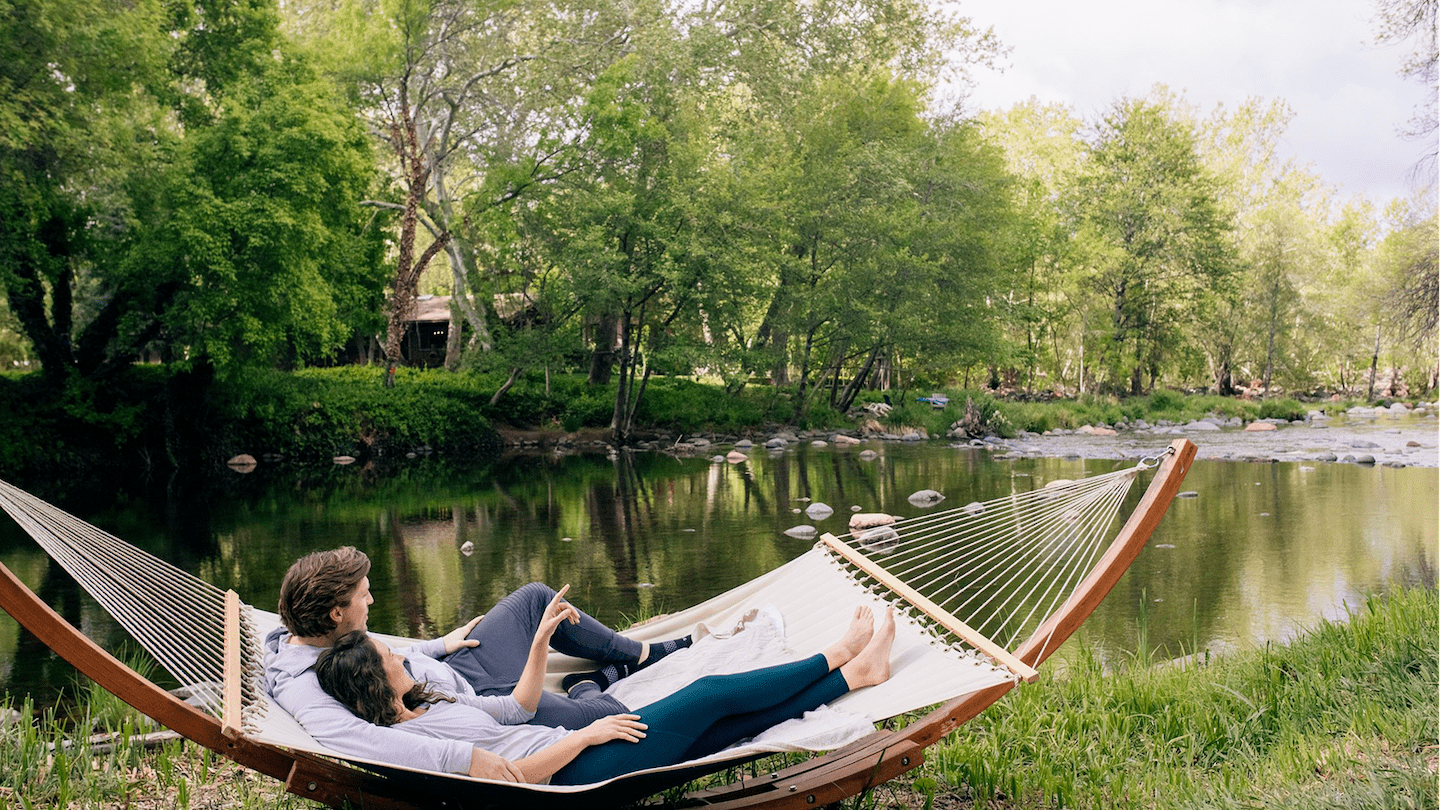 couple laying in hammock along the creek