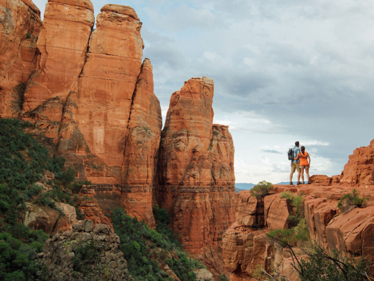 couple standing on the edge of a cliff at the grand canyon