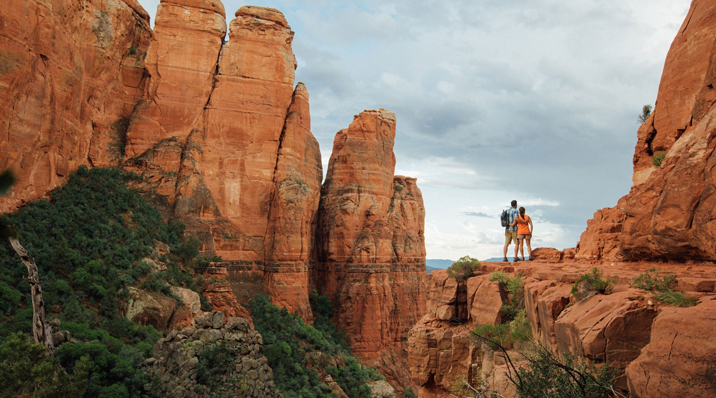 couple standing on the edge of a cliff at the grand canyon