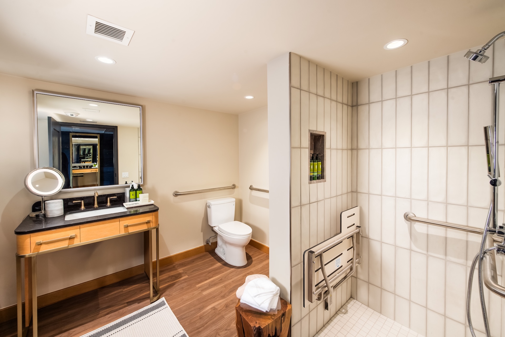 A clean and modern bathroom with a shower, toilet, sink, and mirror.