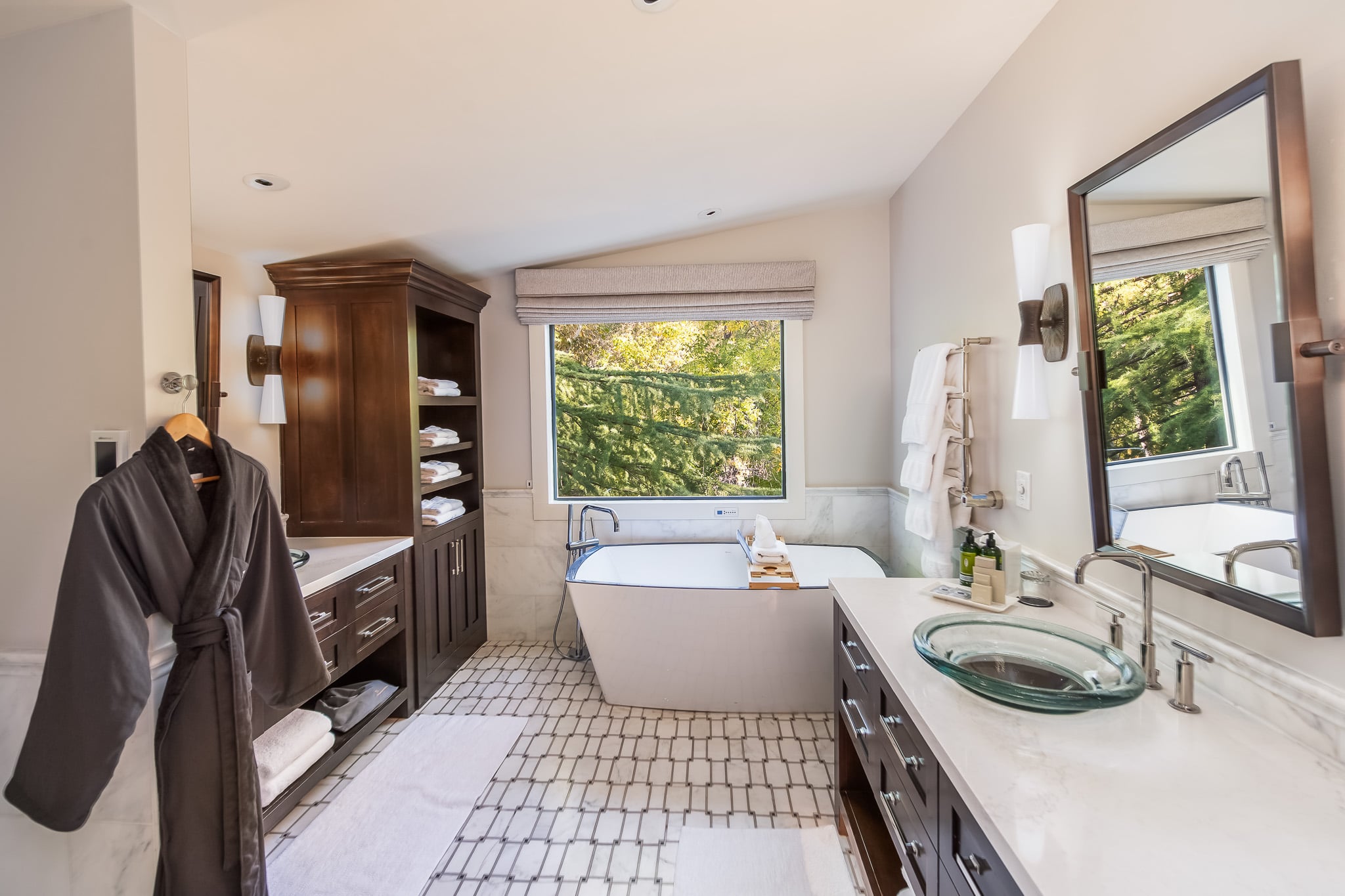 A luxurious bathroom with a soaking tub, double vanity, and large mirror