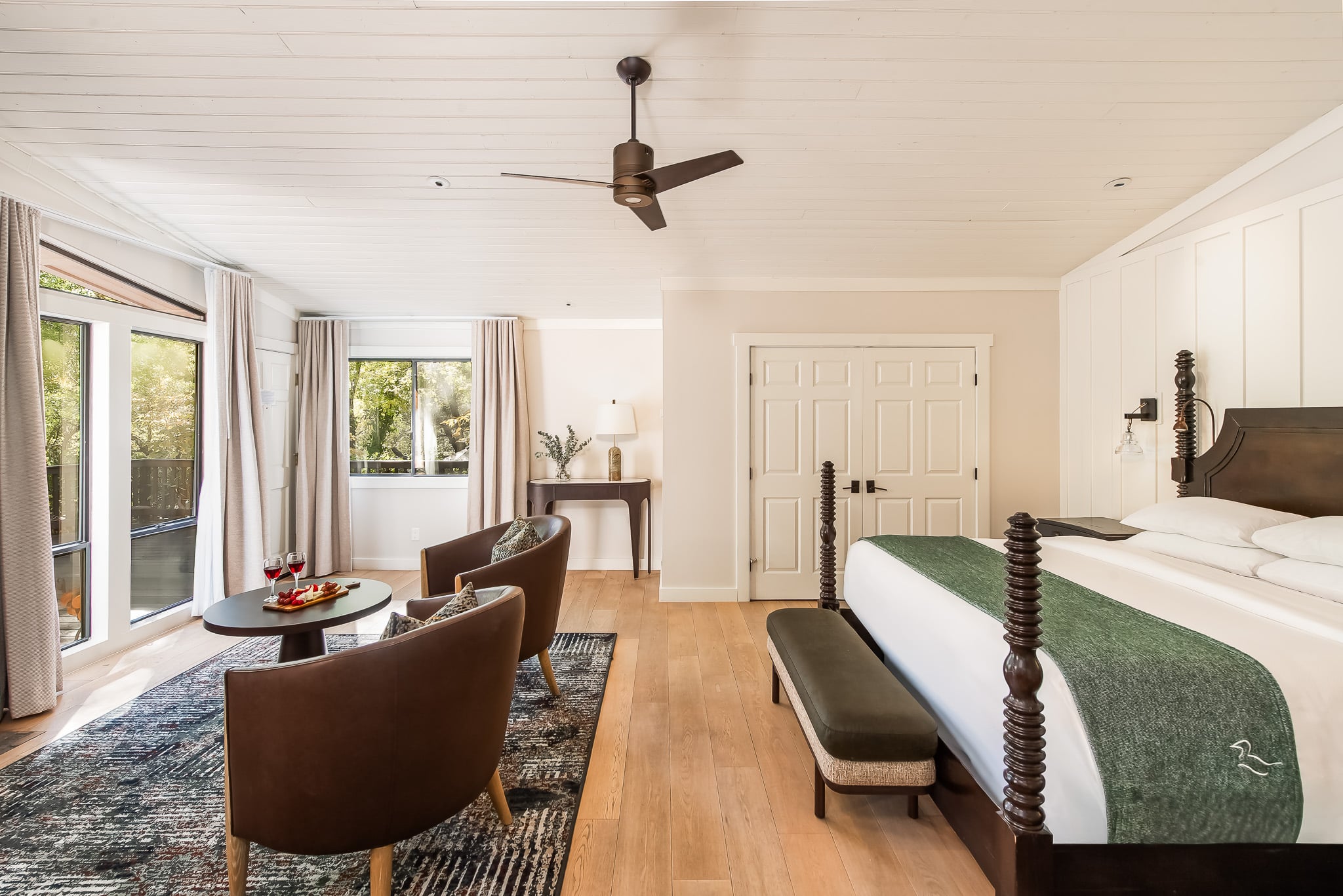 A hotel room with a bed, chairs, and a table