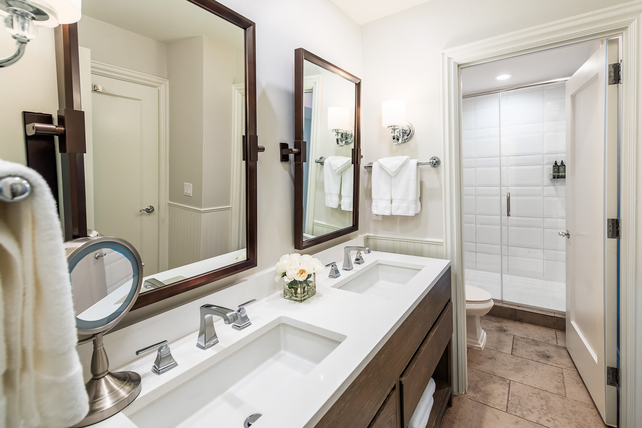 A clean and modern bathroom with a double vanity, two sinks, and a shower