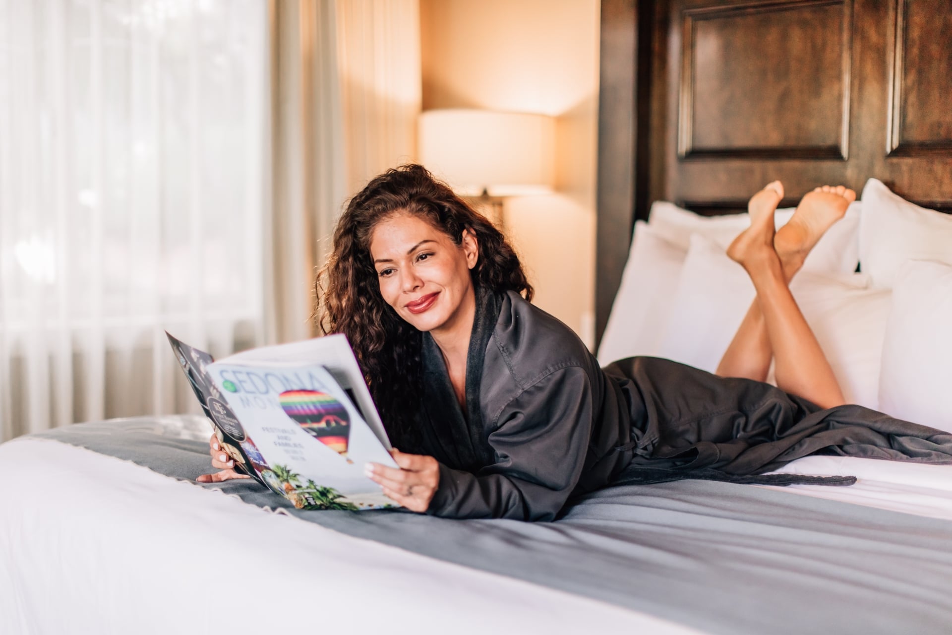 Female guest reading a magazine in bed